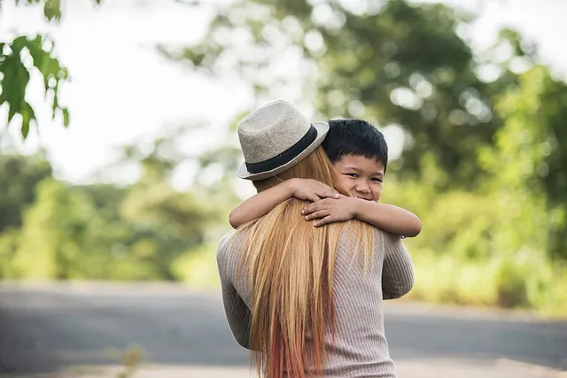 madre con sombrero abraza niño